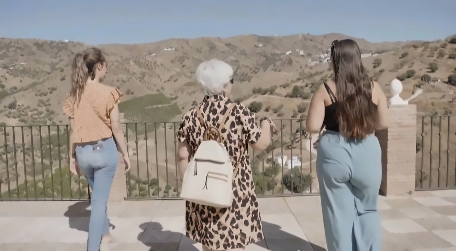María del Mar caminando junto a sus hijas, de espaldas, mirando el paisaje